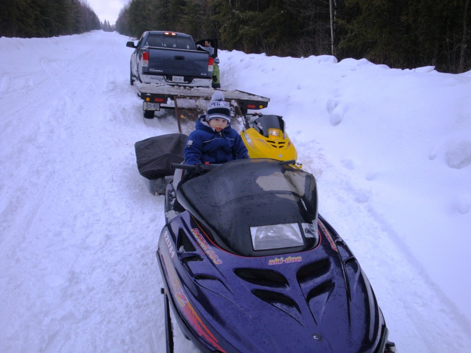 Kids riding Ski-dous during an ice fishing trip