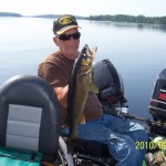 man in hat holding up walleye he caught