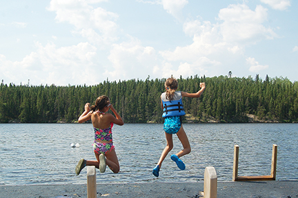 two kids jumping into lake