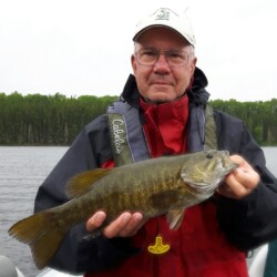 man smiling with bass he caught