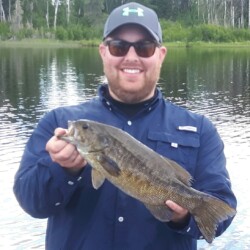 man in sunglasses with bass fish he caught